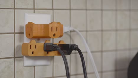 An-outlet-is-fitted-with-plug-splutters-and-several-cords-are-plugged-in-already