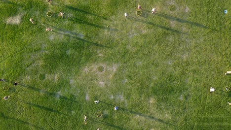 Top-down-aerial-view-of-timelapse-of-many-people-playing-spikeball-in-a-field