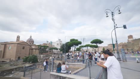 Rome-Immersive-POV:-Moving-In-Busy-Streets-to-Chiesa-Santi-Luca-e-Martina,-Italy,-Europe,-Walking,-Shaky,-4K-|-Tourists-Looking-At-Old-Ruins