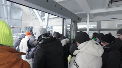 Tourists-Getting-Off-Zugspitze-Gondola-In-Winter-In-Grainau,-Germany