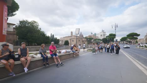 Rome-Immersive-POV:-Moving-In-Busy-Streets-to-Chiesa-Santi-Luca-e-Martina,-Italy,-Europe,-Walking,-Shaky,-4K-|-Man-Selling-Water-To-Passing-Tourists