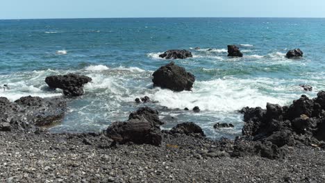 Ocean-waves-and-stones-on-coastline-of-Tenerife,-slow-motion-view