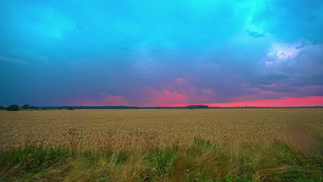 Timelapse-of-rain-showers-moving-over-a-field-while-sky-colors-by-sunset