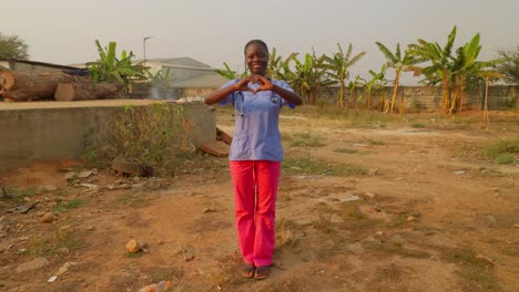 black-female-nurse-doc-doctor-in-Africa-make-heart-with-hands-gesture-sign-sharing-love-in-remote-clinic-charity-hospital-village