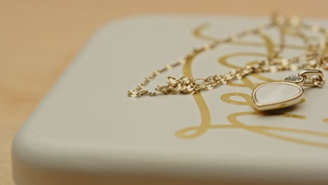 Macro-pan-of-a-beautiful-golden-necklace-on-the-top-of-a-jewelry-box