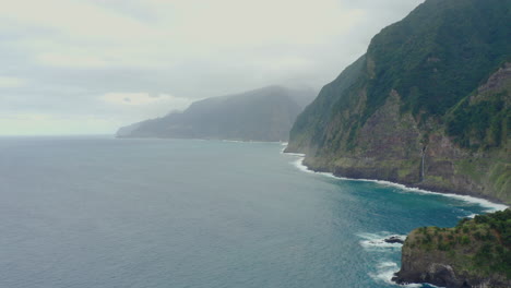 Línea-Costera-Miradouro-Do-Véu-Da-Noiva-Cascada-Madeira-Drone-Shot-Montaña-Con-Olas-Cielo-Panorámico-Océano,-Playa