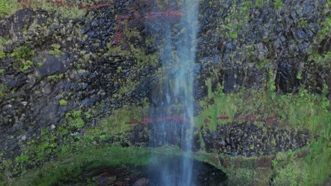 Hiden-waterfall-in-Madeira-forest,-drone-crane-shot