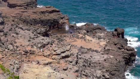 Naklele-Blowhole-exploding-on-the-rocky-cliffs-with-pacific-ocean-in-the-background-on-Maui,-Hawaii,-United-States