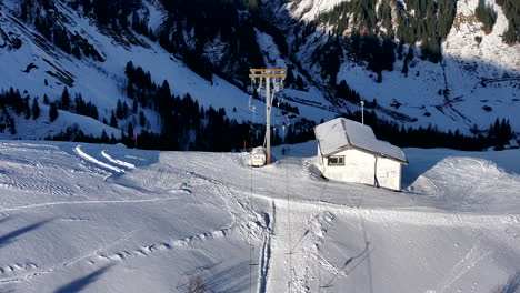 Zoomed-slowmo-drone-tilt-shot-of-moving-drag-ski-lift-on-a-skislope-in-Switzerland