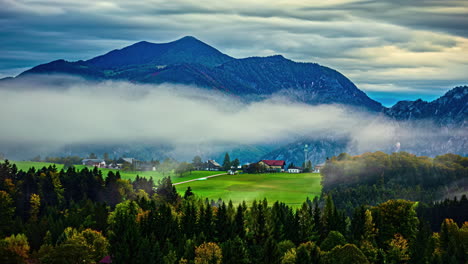 Time-lapse-of-clouds-flying-over-Attersee-village-adorned-by-mountains,-forest