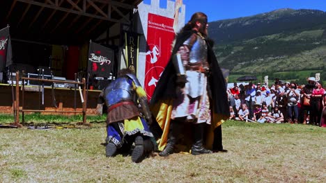 A-comical-scene-with-knights-performed-by-Burdyri,-a-professional-sword-and-stage-combat-team,-during-the-South-Tyrolean-Medieval-Games-2023,-hand-held