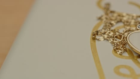 Macro-reveal-of-a-beautiful-golden-necklace-with-a-drop-shaped-locked