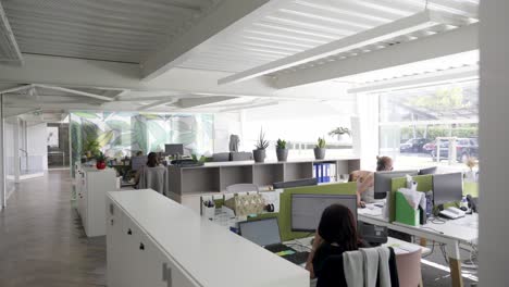 Big-modern-office-space-with-employees-working-behind-desk-reveal-shot