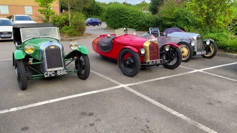Three-classic-old-antique-racing-cars,-vintage-cars-at-a-parking-in-England,-exclusive-expensive-collectible-cars,-single-seat,-4K-shot