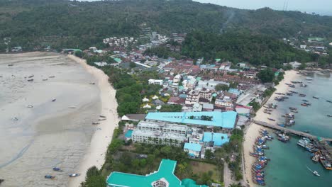 Town-hospital-and-pier-of-Phi-phi-island-at-low-tide,-Aerial