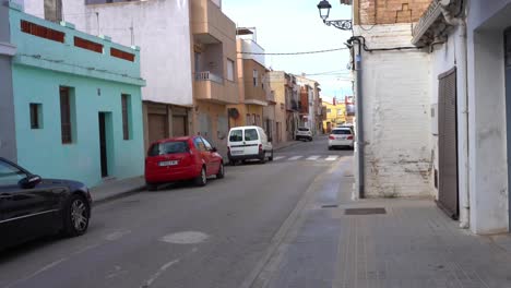 Car-passing-through-narrow-street-in-traditional-neighborhood,-Valencia