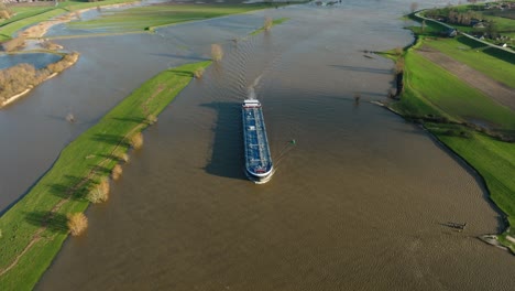 Handelsschiff,-Das-Güter-Den-überfluteten-Fluss-Lek-Hinauf-Transportiert