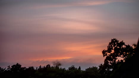 Low-angle-timelapse-of-colorful-sunset-with-veil-clouds-in-summer-time