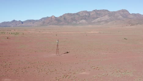 Aerial-view-of-Flinders-Ranges-mountains-and-desert-windmill,-South-Australia