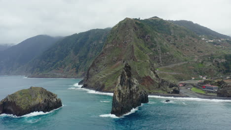 Ribeira-da-Janela-Porto-Moniz-Seixal-Madeira-drone-shot-fly-towards-the-rocks-with-sea-ocean-waves-on-a-cloudy-day