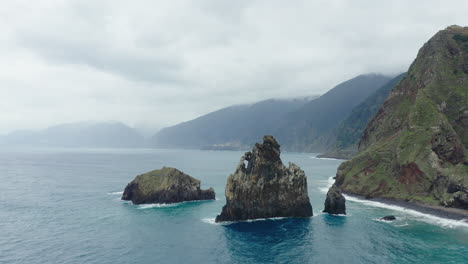Ribeira-da-Janela-Porto-Moniz-Seixal-Madeira-drone-shot-fly-around-the-rocks-with-sea-ocean-waves-on-a-cloudy-day