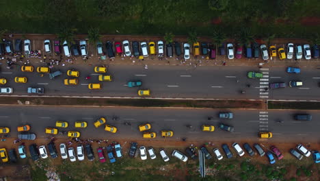 Aerial-view-over-taxis-and-parked-cars-at-a-fair-in-Yaounde,-Cameroon,-Africa