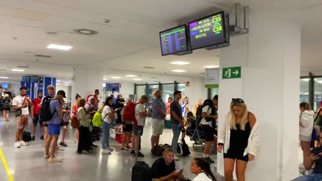 People-waiting-at-the-gate-in-line-to-board-an-airplane-in-Malaga-international-airport,-holiday-vacation-time,-4K-shot