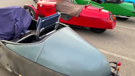 Three-classic-old-antique-cars,-vintage-cars-at-a-parking-in-England,-expensive-collectible-cars,-racing-single-seat,-4K-shot