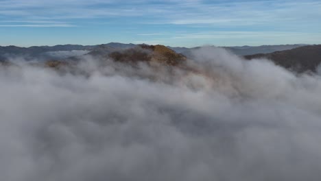 Picos-Montañosos-Que-Emergen-De-Una-Densa-Inversión-De-Nubes-Debajo-Del-Cielo-Azul