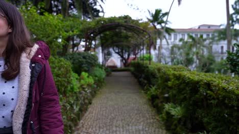 Woman-strolls-amid-lush-plants-in-Jardim-Duque-da-Terceira,-Angra-do-Heroismo