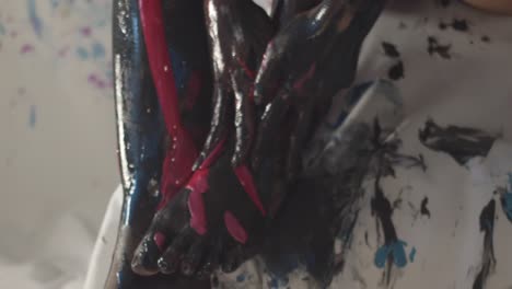 Handheld-close-up-of-girl’s-hands-touching-her-legs-covered-in-paint