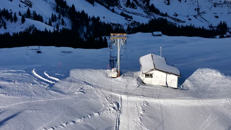 Zoomed-drone-tilt-shot-of-moving-drag-lift-on-a-skislope-in-Switzerland