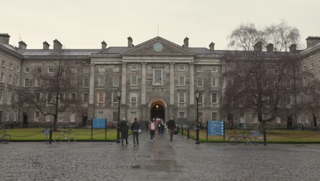 Students-Walking-On-Wet-Courtyard-Of-Trinity-College-Dublin-In-Ireland