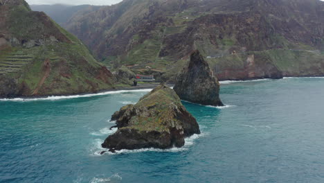 Ribeira-Da-Janeport-Porto-Moniz-Seixal-Madeira-Drohnenschuss-Fliegt-Um-Felsen-Mit-Meereswellen,-Bewölkten-Bergen