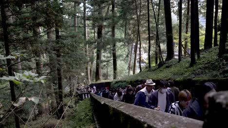 At-a-leisurely-pace,-visitors-ascend-the-staircase-leading-to-Okusha-Hoto-in-Nikko,-Japan,-to-explore-the-structure-that-houses-the-remains-of-Tokugawa-Ieyasu
