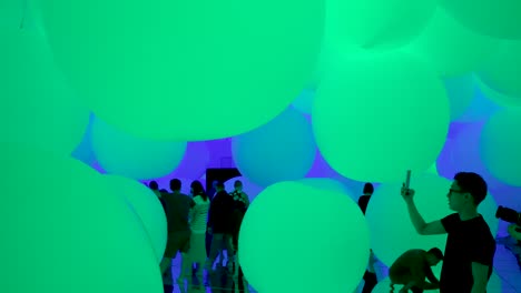 Besucher-Erfreuen-Sich-An-Einer-Kunstausstellung-Im-Teamlab-Planets-In-Tokio,-Japan,-Umgeben-Von-Immersiven-übergroßen-Ballons,-Die-Ihre-Farben-Wechseln