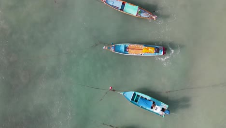 Aerial-Birds-Eye-View-Along-Row-Of-Moored-Empty-Boats-Off-Sairee-Beach