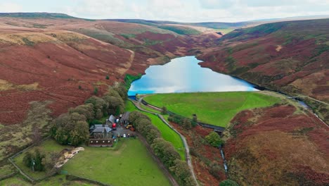 Aerial-drone-video-of-the-beautiful-English-countryside,-Wild-landscape-showing-moorlands-covered-in-heather,-large-lakes-and-blue-water