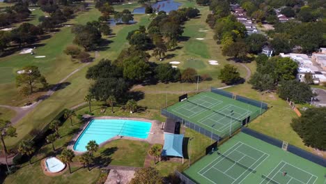 Aerial-view-of-Golf-course,-with-tennis-courts-and-a-swimming-pool,-at-60-frames