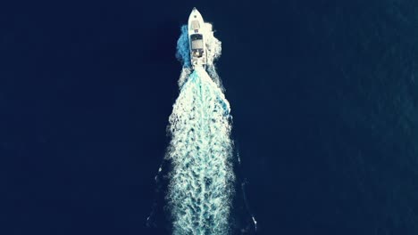 Overhead-shot-of-yacht-sailing-through-a-calm-sea-on-a-summer-day-on-vacation