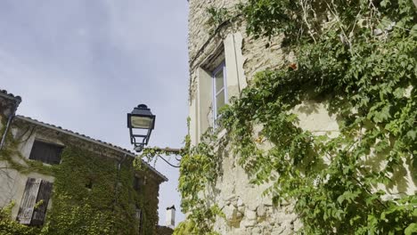 old-historical-street-lamp-on-an-old-house-wall-of-a-French-stone-house-in-good-weather