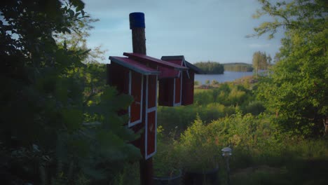 Pajarera-Roja-Casera-En-Un-Jardín-Junto-A-Un-Lago-En-Suecia