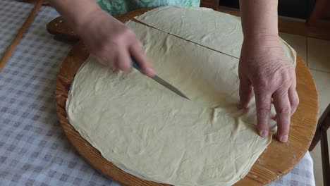 Messer-In-Der-Hand,-Teig-Schichten,-Traditioneller-Kuchen-Zum-Backen-Bereit-–-Balkan-Kochkunst-In-Bewegung