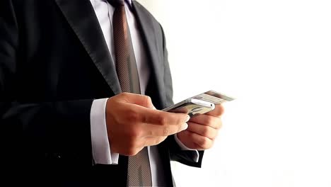 In-a-crisp-suit,-a-businessman-confidently-taps-credit-card-details-into-his-phone