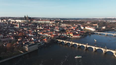 Flying-above-Vltava-river-and-Charles-bridge-in-Prague-city,-Czech-Republic