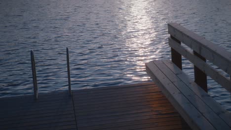 Ladder-and-wooden-bench-on-a-swimming-pier-in-a-calm-lake-in-Sweden