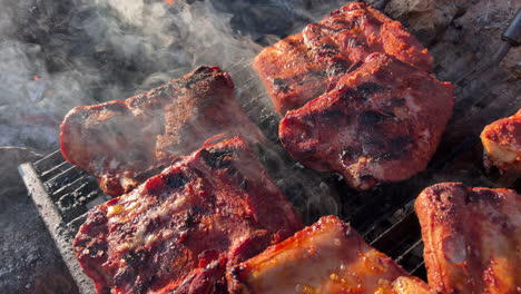 Cooking-juicy-bbq-pork-ribs-on-an-outdoor-fire-grill-with-smoke-and-ashes,-delicious-food,-4K-static-shot