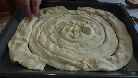 Grandmother's-Wrinkled-Hands-Carefully-Placing-Pie-Dough-in-Tray-for-Baking---Cherished-Culinary-Craft