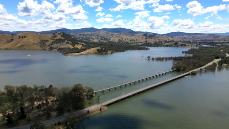 Lake-Eildon-full-of-water,-long-pan-from-drone-on-blue-sky-day