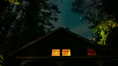 Zeitraffer-Der-Sterne-Hinter-Einer-Rustikalen,-Gemütlichen-Hütte-In-Den-Wäldern-Von-Neuengland-An-Einem-Sommerabend,-Wobei-Die-Milchstraße-Hinter-Vorbeiziehenden-Dünnen-Wolken-Sichtbar-Ist